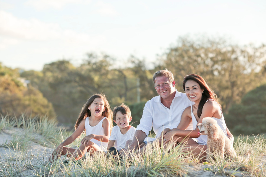 Family of four sitting on a forest clearing